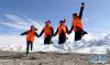 在青藏铁路格拉段玉珠峰站，中铁二十一局电务电化公司信号女子工班“四姐妹”在海拔4100多米的昆仑雪山下一起跳跃（2017年10月23日摄）。