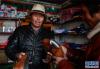西藏阿里地区改则县物玛乡抢古村村民阿祖(左)在合作社商店内销售皮鞋(3月15日摄)。新华社记者 刘东君 摄