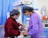 玉树藏族自治州人民医院医生吉安（左）和护士卡要在新生儿/儿童重症监护室为新生儿换药（4月12日摄）。