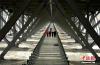 该桥全桥长1411米，系超大跨径钢桁梁悬索桥，被誉为“川藏第一桥”，大桥预计2018年8月底实现贯通。图为工程技术人员正在对兴康特大桥钢桁梁展开巡查。 中新社记者 刘忠俊 摄