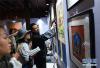 5月4日，参加巡展活动的西藏画师（右）向观众介绍唐卡等艺术作品。