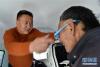 5月9日，爱心企业人士金小友（左）为藏区老人检查视力。