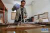 次仁多杰的大儿子格桑旦增在藏纸厂内制作藏纸（5月23日摄）。新华社记者 刘东君 摄