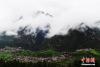 处在云雾环绕下的藏族村寨。杨艳敏 摄
