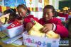 6月20日，甘肃省甘南藏族自治州夏河县吉仓乡中心寄宿制小学的孩子查看“HELLO小孩”爱心套餐包内的物品。