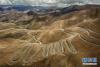 修筑于西藏日喀则市定日县群山峻岭间蜿蜒曲折的公路（7月24日无人机拍摄）。