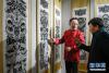 中国工艺美术大师、黑龙江省非遗保护项目代表性传承人刘延山（左）为日喀则市民讲解萨满剪纸技艺（8月26日摄）。 