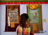 8月27日，一名安徽观众在欣赏勉萨画派唐卡。  新华社记者 晋美多吉 摄