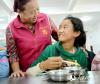 在食堂里，爱心“妈妈”和一名藏族学生用普通话交流。