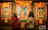11月20日，四川炉霍，民族手工艺技术培训基地内收藏的精美唐卡画吸引参观者。