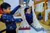 11月30日，孩子们在展示马上就要编织完成的爱心围巾。新华社记者 徐昱 摄