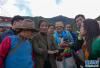 公尊德姆农庄创始人德吉旺姆（前左二）给客人看手机里的南迦巴瓦峰美图（9月28日摄）。新华社记者 旦增尼玛曲珠 摄