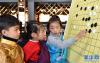 12月9日，孩子们围着棋盘“切磋”。新华社记者 觉果 摄
