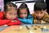 12月9日，爱好藏棋的孩子们与棋盘合影。新华社记者 觉果 摄