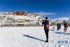 12月19日，一名游客在布达拉宫广场上拍摄雪景。 12月18日，西藏拉萨市迎来今年入冬以来的首场降雪。19日清晨，拉萨雪后初霁，处处银装素裹，尽显雪域高原之美。 新华社记者刘东君摄