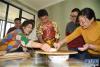 2月4日，炜典（右三）在小伙伴李天润（右二）家中学习包饺子。新华社记者 王凯 摄