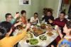 2月4日，贵桑格列（左四）、炜典（左三）和对口家庭李天润（左二）一家举杯庆祝除夕佳节。新华社记者 王凯 摄