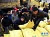 2月13日，玉树藏族自治州杂多县受灾牧民在搬运牛羊颗粒饲料。