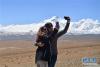4月26日，两名外籍游客在希夏邦马峰附近拍照留念。新华社记者 晋美多吉 摄