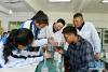 5月7日，在山南市第一高级中学，来自湖北省襄阳的援藏老师蔡春亭（中）和本地老师次仁曲旦（右后）指导学生做化学实验。