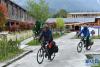 5月17日，两名骑行者进入古村一处家庭旅馆。新华社记者 李鑫 摄