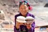 5月22日，西藏纳西民族乡加达村村民曲措展示所卖盐类商品。新华社记者 李鑫 摄