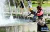 6月25日，在拉萨市宗角禄康公园，一名儿童在家长的陪伴下戏水。新华社记者 李鑫 摄