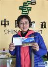 7月25日，来自湖北的游客钱雅萍在神山圣湖主题邮局展示购买到的明信片。新华社记者 晋美多吉 摄