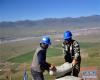 8月10日，在青海省玉树藏族自治州治多县加吉博洛镇境内的一处海拔4400余米的电网建设工地上，工人索朗叶西（左）和曾朝万在搬运水泥。新华社记者 张龙 摄