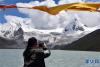 一名游客在拍摄萨普雪山风景（8月24日摄）。新华社记者 黄豁 摄