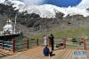 8月31日，游客在卡若拉冰川景区游览。 卡若拉冰川位于西藏山南市浪卡子县和日喀则市江孜县交界处。巨大的冰川从山顶云端一直延伸到离307省道只有几百米的地方。 新华社记者 李鑫 摄