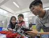在位于陕西咸阳的西藏民族大学，“智慧星机器人教育”大学生创业项目成员李世伟（右）在辅导小学员搭建模型（10月11日摄）。新华社记者 李键 摄