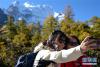 10月20日，在亚丁景区，游客在拍照合影。新华社发（唐文豪 摄）