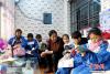 11月13日，勤考陪孩子们看书学习。今年34岁的勤考是青海省黄南州河南蒙古族自治县的一位普通的藏族妇女，她在6年间先后照料起7名牧区困境儿童的生活，加上自己的2个孩子，她一共照看着9个孩子。中新社记者 马铭言 摄