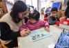 12月11日，小朋友在老师的带领下绘制爱心卡片，准备随围巾一起寄给西藏的小朋友们。新华社记者 徐昱 摄