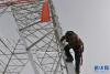 穿戴安全防护装备的高空人员开始攀爬铁塔 新华社记者 侯捷 摄