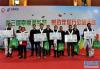 12月23日，在拉萨火车站，中国邮政集团公司西藏自治区分公司和青藏铁路公司负责人与受助务工人员代表合影。新华社记者 张汝锋 摄