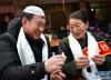 1月15日，在拉萨市城关区德瑟大院，藏族大姐卓玛次仁（右）和来自甘肃的商人马麻乃比赛包饺子。 新华社记者 觉果 摄