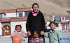 1月20日，格桑卓嘎牵着孩子的手走在森布日极高海拔地区生态搬迁安置点内。新华社记者 觉果 摄