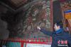 图为索南嘉介绍拉卜楞寺佛殿壁画修复情况。中新社记者 杨艳敏 摄