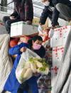 在拉萨城投农副产品批发市场，工作人员从一辆西藏农产品保供运输车上卸载蔬菜（2月6日摄）。新华社记者张汝锋摄