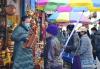 2月14日，拉萨市八廓街上的商户（左）向顾客推销藏历新年藏家供奉以及迎接贵客的一种五谷丰收斗，藏语称“切玛”。新华社记者 张汝锋 摄
