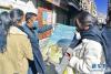 2月14日，拉萨市城关区吉崩岗街道策门林社区工作人员准备张贴西藏自治区卫健委分发的疫情防控海报。 新华社记者 张汝锋 摄