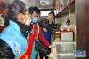 拉萨市城关区八廓街道绕赛社区党员志愿者帮居民央宗（右）处理冰箱里的过期食品（2月18日摄）。新华社记者 张汝锋 摄