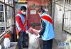 拉萨市城关区八廓街道绕赛社区党员志愿者帮居民央宗家处理垃圾（2月18日摄）。新华社记者 张汝锋 摄