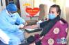 2月21日，西藏自治区党委宣传部的志愿者李坤一（右）在西藏自治区血液中心采血车上无偿献血。
