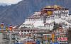 2月26日是藏历新年初三，按照传统习俗，藏族民众在屋顶悬挂崭新的五彩经幡，祈求新的一年里五谷丰登、吉祥如意。中新社记者 何蓬磊 摄