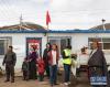 当雄县乌玛塘乡巴嘎村的村民注视着当雄电信局技术人员拉网布线（3月6日摄）。新华社记者 普布扎西 摄