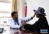 玉树州藏医院肝病科专家扎西帮巴（左）在给患者把脉（资料照片）。新华社发