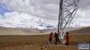 6月23日，阿里与藏中联网工程查务至吉隆500千伏线路新建工程施工人员完成作业返回地面，远处是海拔8027米的希夏邦马峰。新华网 达珍 摄